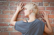 Photo: Beautiful blond against brick wall portrait Beautiful blond against brick wall portrait