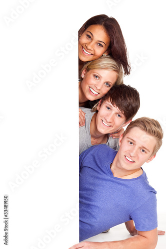Foto: vier junge leute mit hinweisschild vier junge leute mit hinweisschild