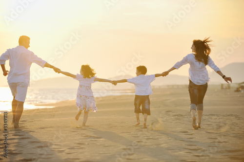 Photo: happy young family have fun on beach happy young family have fun on beach