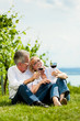 Glückliches Paar trinkt Wein am See im Sommer