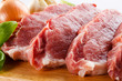 Raw pork on cutting board and vegetables