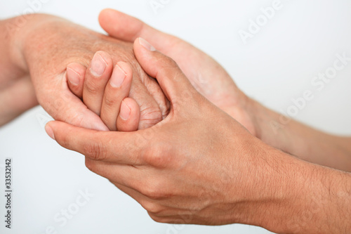 Photo: Junger Mann hält verständnisvoll Hand einer älteren Frau Junger Mann hält verständnisvoll Hand einer älteren Frau