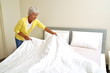 Seniorin beim bettenmachen