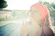 Young girl blowing soap bubbles