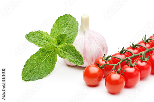 Photo: A studio shot of mint leaves, garlic and cherry tomatoes A studio shot of mint leaves, garlic and cherry tomatoes