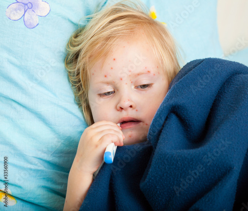 Photo: a sick girl is measuring the temperature a sick girl is measuring the temperature