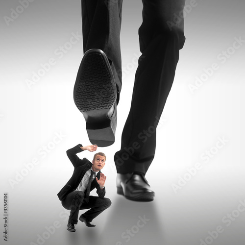 Foto: Homme d'affaire se faisant écraser par un géant Homme d'affaire se faisant écraser par un géant