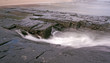 Wave retracting over rocks with blurred motion patterns