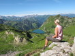 Junge Frau betrachtet Bergsee