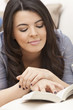 Happy Hispanic Woman Reading Paperback Book at Home