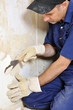 Handwerker beim Entfernen von Tapetenresten