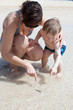 Mother and son pointing at something in the sand