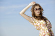 beautiful girl in sunglasses on background blue sky