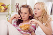 two women watching television at home