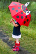 The little girl with an umbrella and in rubber boots