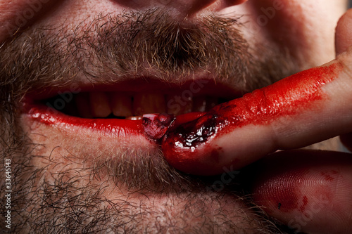 Photo: Crazy nailbiter. A man biting of his nails, close up Crazy nailbiter. A man biting of his nails, close up