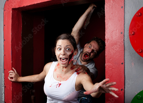 Photo: Killer with a machete in his hand, chasing young woman with a bi Killer with a machete in his hand, chasing young woman with a bi