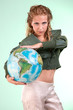 Pretty blonde woman holding globe of world