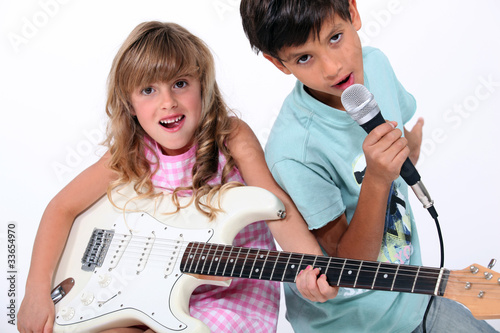 Photo: Little boy and girl playing musical instruments Little boy and girl playing musical instruments