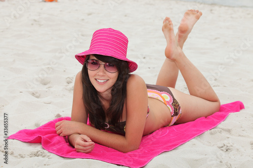 Photo: young woman lying down on the beach young woman lying down on the beach