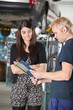 Mechanic showing bill to a woman