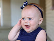 baby girl holding her ear in pain
