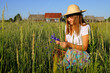 Girl with cornflowers in the field against village