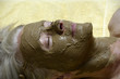 Ältere Frau mit Gesichtsmaske aus Heilerde