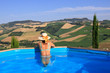 Photo: Frau schaut aus Pool mit toller Aussicht - Toskana, Marken, Ital Frau schaut aus Pool mit toller Aussicht - Toskana, Marken, Ital