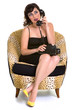 Brunette sitting and talking on a old phone in yellow shoes