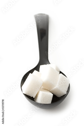 Photo: Sugar in a spoon isolated over white background Sugar in a spoon isolated over white background