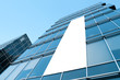 blue glass wall with blank placard of skyscraper