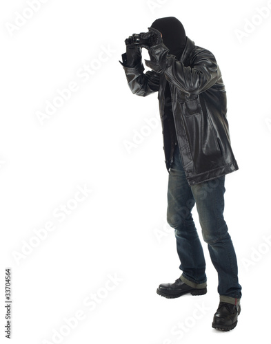 Photo: thief in black clothes and balaclava using binoculars thief in black clothes and balaclava using binoculars