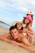 Portrait of family laying down sandy beach