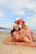 Portrait of family laying down sandy beach