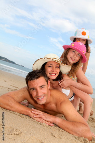 Photo: Portrait of family laying down sandy beach Portrait of family laying down sandy beach