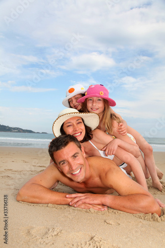 Photo: Portrait of family laying down sandy beach Portrait of family laying down sandy beach