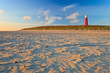 Seaside with sand dunes and lighthouse at sunset Seaside with sand dunes and lighthouse at sunset