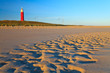 Seaside with sand dunes and lighthouse at sunset Seaside with sand dunes and lighthouse at sunset