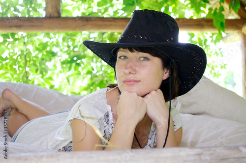 Photo: beautiful girl in the hat lying in the open air beautiful girl in the hat lying in the open air