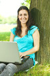 happy young woman using laptop outdoors
