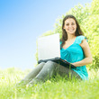 happy young woman using laptop outdoors