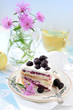 Bouquet of cornflowers and piece of cake with black raspberry Bouquet of cornflowers and piece of cake with black raspberry
