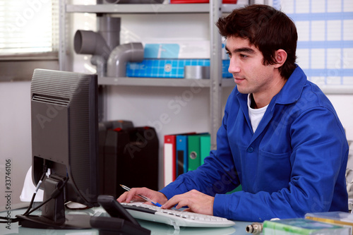 Photo: Plumber using desktop computer Plumber using desktop computer
