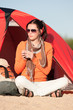 Camping happy woman sitting front of tent