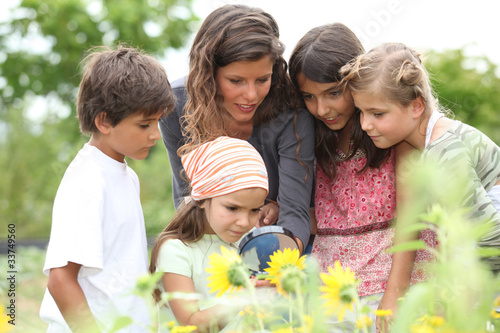 Photo: children having a nature class in the park children having a nature class in the park