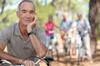 Photos : Senior on a bike with friends in the background
