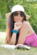 Woman with a book in a park looking straight to you Woman with a book in a park looking straight to you