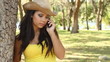 Pretty young woman in cowboy hat talking on mobile phone