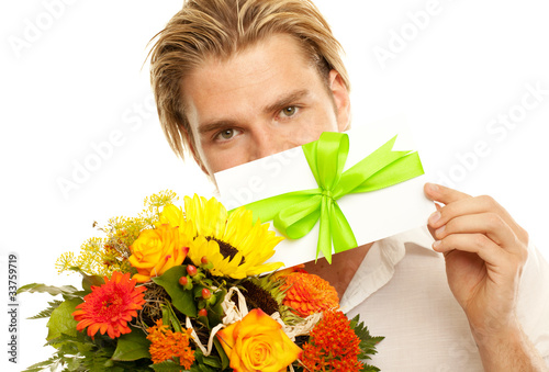 Photo: attraktiver junger mann mit blumen und gutschein attraktiver junger mann mit blumen und gutschein